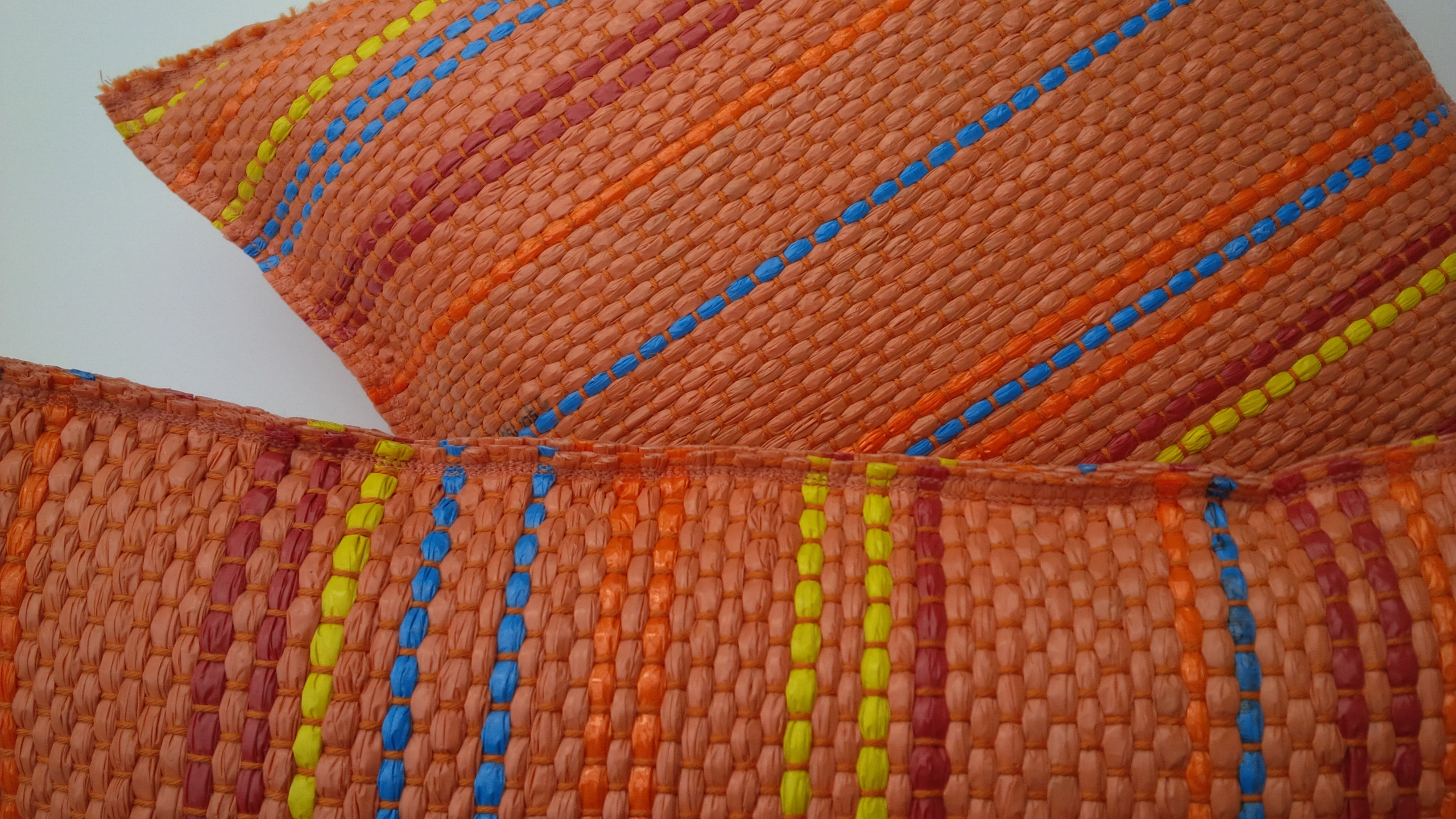 Orange pillow with blue, yellow and red